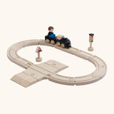 A PlanToys my first train set showing a small wooden boy doll sitting on the carriage