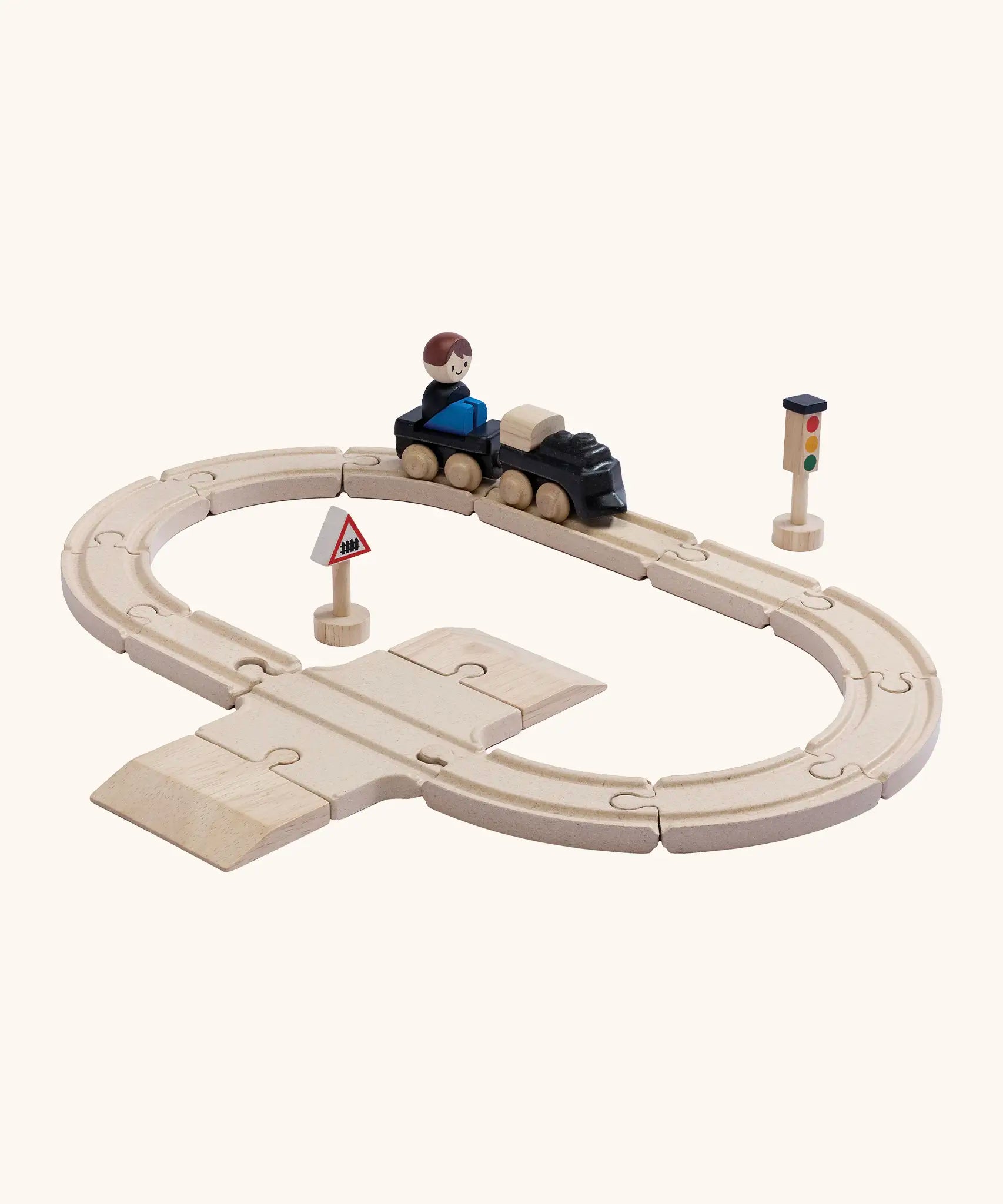 A PlanToys my first train set showing a small wooden boy doll sitting on the carriage
