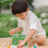 Child holding animal figures from the PlanToys pet shop outdoors showing scale 