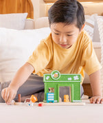 Child playing with a animal figure next to the PlanToys pet shop play set