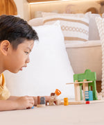 Back of the PlanToys pet shop with a child playing with different animal figures