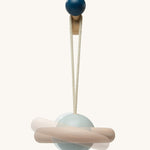 A closer view of the plant toy from the PlanToys Play Gym in Orchard. The planet is light blue with a natural wooden ring around it, and the image has a second, faded image behind it to show the movement of the toy.