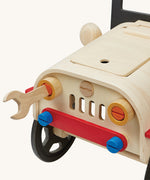 The wooden wrench being used to loosen and tighten the headlights on the PlanToys Motor Mechanic. There are other parts that can also be removed on the front of the car