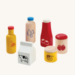 PlanToys kids wooden food and beverage toy set laid out on a cream background.
