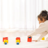 Child playing with PlanToys nesting  wooden toys, triangle, square and circle. 