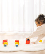 Child playing with PlanToys nesting  wooden toys, triangle, square and circle. 