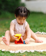 Child playing with the PlanToys nesting triangle wooden toy. 