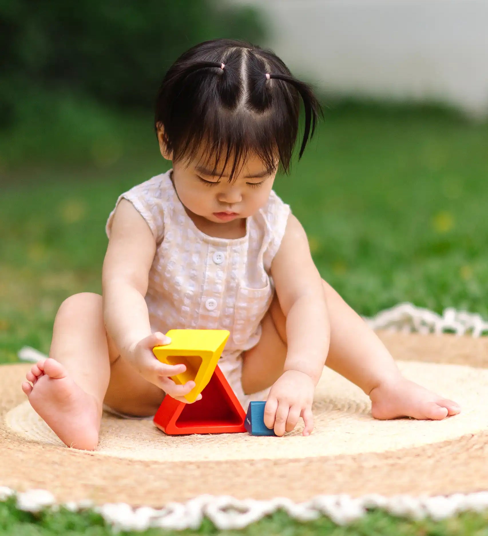 Child playing with the PlanToys nesting triangle wooden toy. 