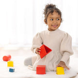 PlanToys nesting triangle wooden toy. Other nesting shapes sets are in the background.