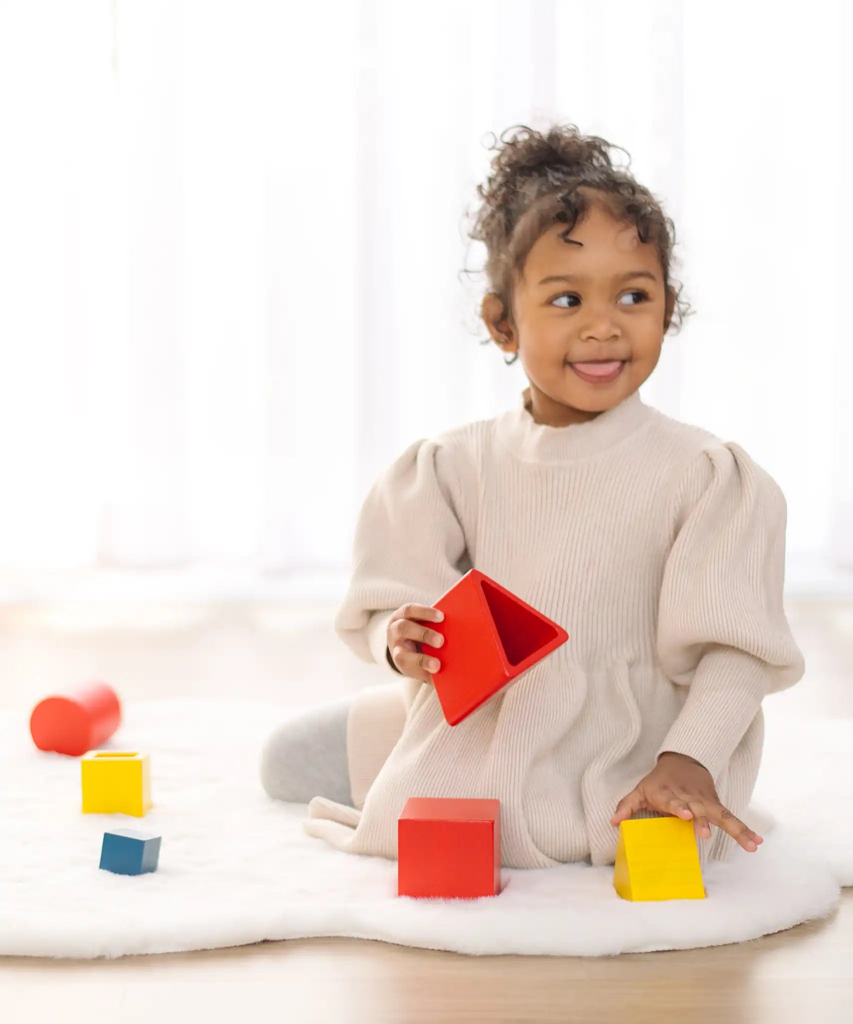 PlanToys nesting triangle wooden toy. Other nesting shapes sets are in the background.