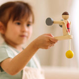 Child playing with the PlanToys Weightlifting Acrobat wooden toy.