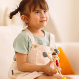Child playing with the PlanToys Weightlifting Acrobat wooden toy.