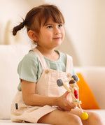 Child playing with the PlanToys Weightlifting Acrobat wooden toy.