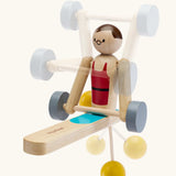 PlanToys Weightlifting Acrobat wooden toy shown with shadows of different movements overlaid on the photo.