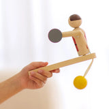 PlanToys Weightlifting Acrobat wooden toy shown in a child's hand.
