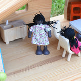 A doll from the PlanToys doll house family set placed in an Ostheimer dolls house.