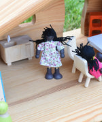 A doll from the PlanToys doll house family set placed in an Ostheimer dolls house.