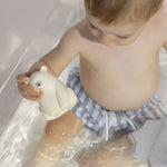 A child playing with the Oli & Carol Polar Bear Bath Toy Set in a bath