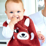 A baby being held by an adult, wearing the Roommate Organic Cotton Baby Bib - Red Panda