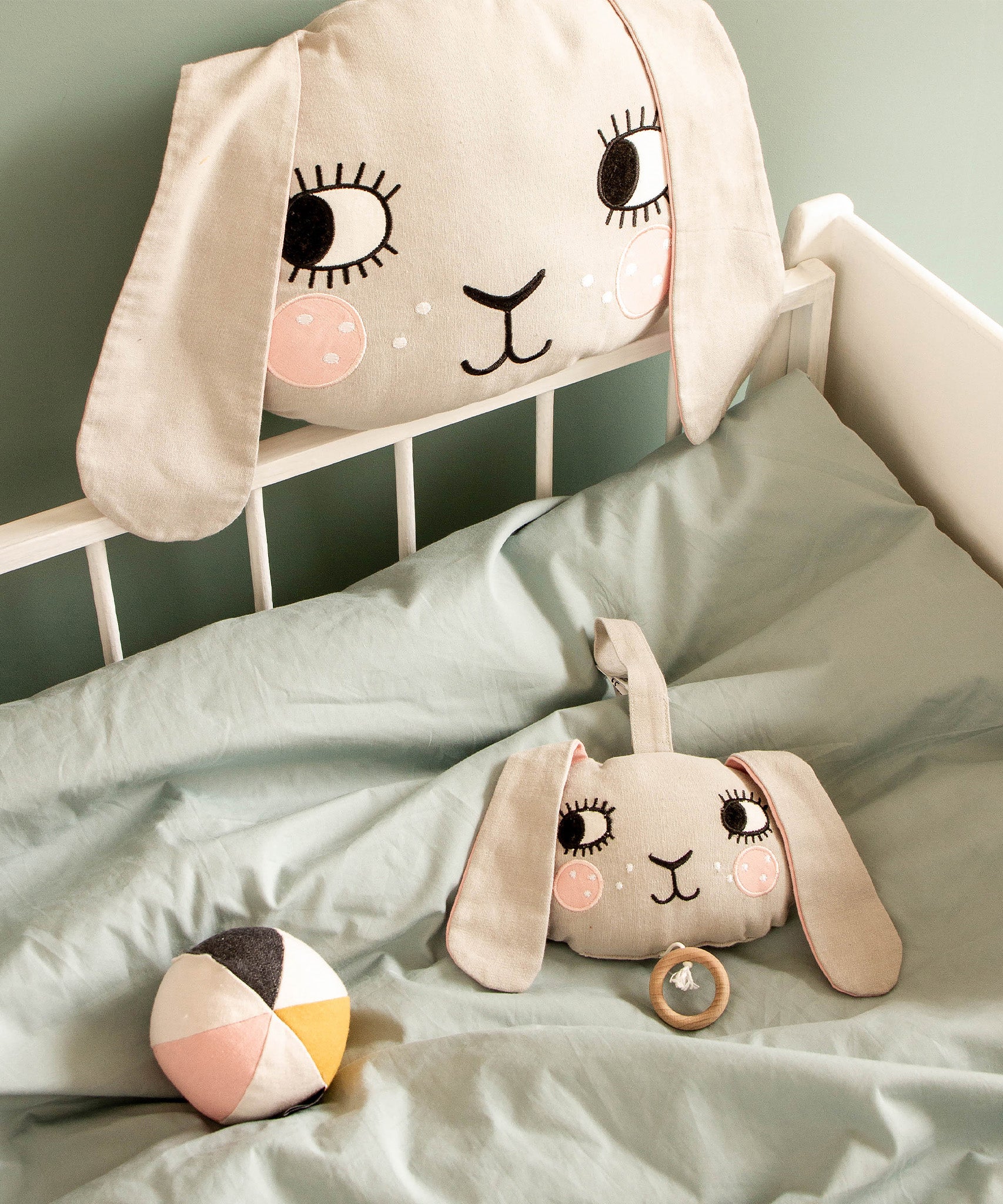 Roommate Musical Baby Mobile - Bunny and Roommate Bunny cushion in a baby bed