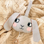 The Roommate Musical Baby Mobile - Bunny on a beige baby blanket