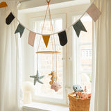 The Roommate Sealife Hanging Mobile hung in front of a window with Roommate Bunting above