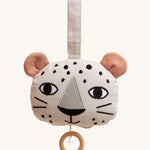 Roommate Musical Baby Mobile - Leopard, in the shape of a leopard face. Made from white fabric with black spots, two pink ears and a pull cord with a wooden hoop handle. On a cream background