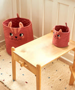 The large and mini Roommate organic cotton storage cat basket in red standing in a playroom showing size comparison