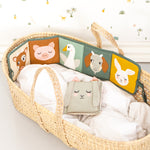 The Roommate Country Life Fabric Book placed on the edge of a Moses basket. Please be advised that supervision is required at all times. 