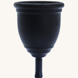 Ruby Cup Menstrual Cup in black silicone, on a cream background