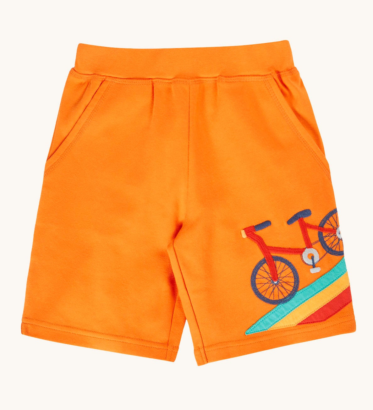 Frugi bright orange children's shorts with rainbow road and bicycle details on one leg. Organic cotton shorts with two pockets.