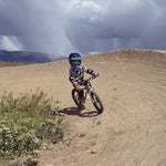 A child on a bike track, riding the Early Rider Seeker X16 16" Bike - Brushed Aluminium