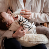 A mother feeding her baby and using the Senger nursing and neck soft warm cushion under the baby as a support. Cushion available at Babipur. 
