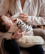 A mother feeding her baby and using the Senger nursing and neck soft warm cushion under the baby as a support. Cushion available at Babipur. 