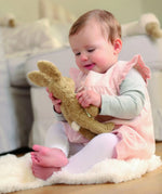 Senger baby rabbit in beige with small white fluffy tail, made with organic cotton and stuffed with wool, held by baby.
