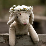 Senger Floppy White Sheep soft toy in size small, made from organic cotton filled with wool, outside wearing a flower crown.