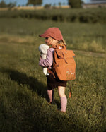 Senger Floppy White Sheep toy, made from organic cotton filled with wool, held by child walking in a field.