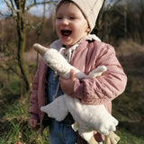 Senger naturwelt white small goose toy, made from organic cotton, held by child.
