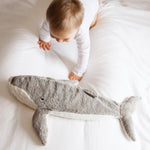 A small child crawling towards the Senger Large Cuddly Whale Toy which is laid on a white sheet