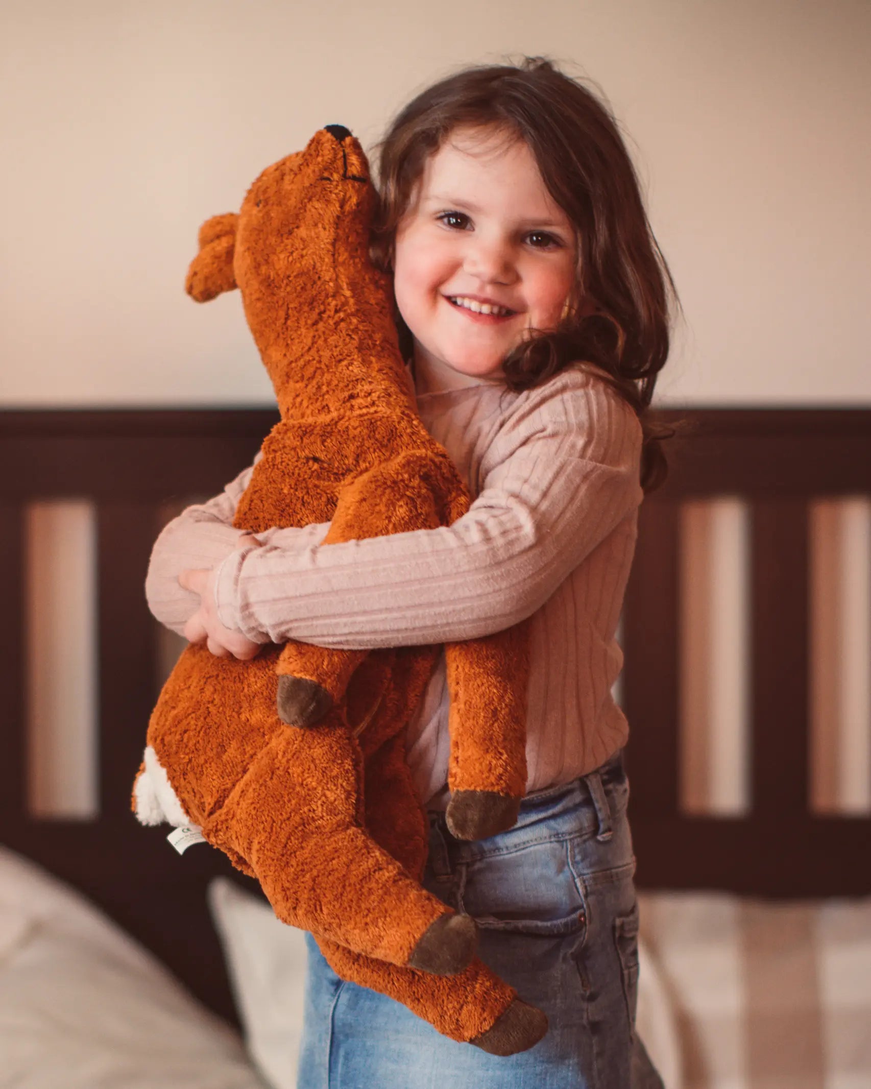 Senger Naturwelt Large Cuddly Deer Soft Toy, made from wool and organic cotton, cuddled by girl.