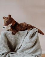 Senger Naturwelt seal, a small brown cuddly soft toy made from natural materials, on a grey muslin blanket.