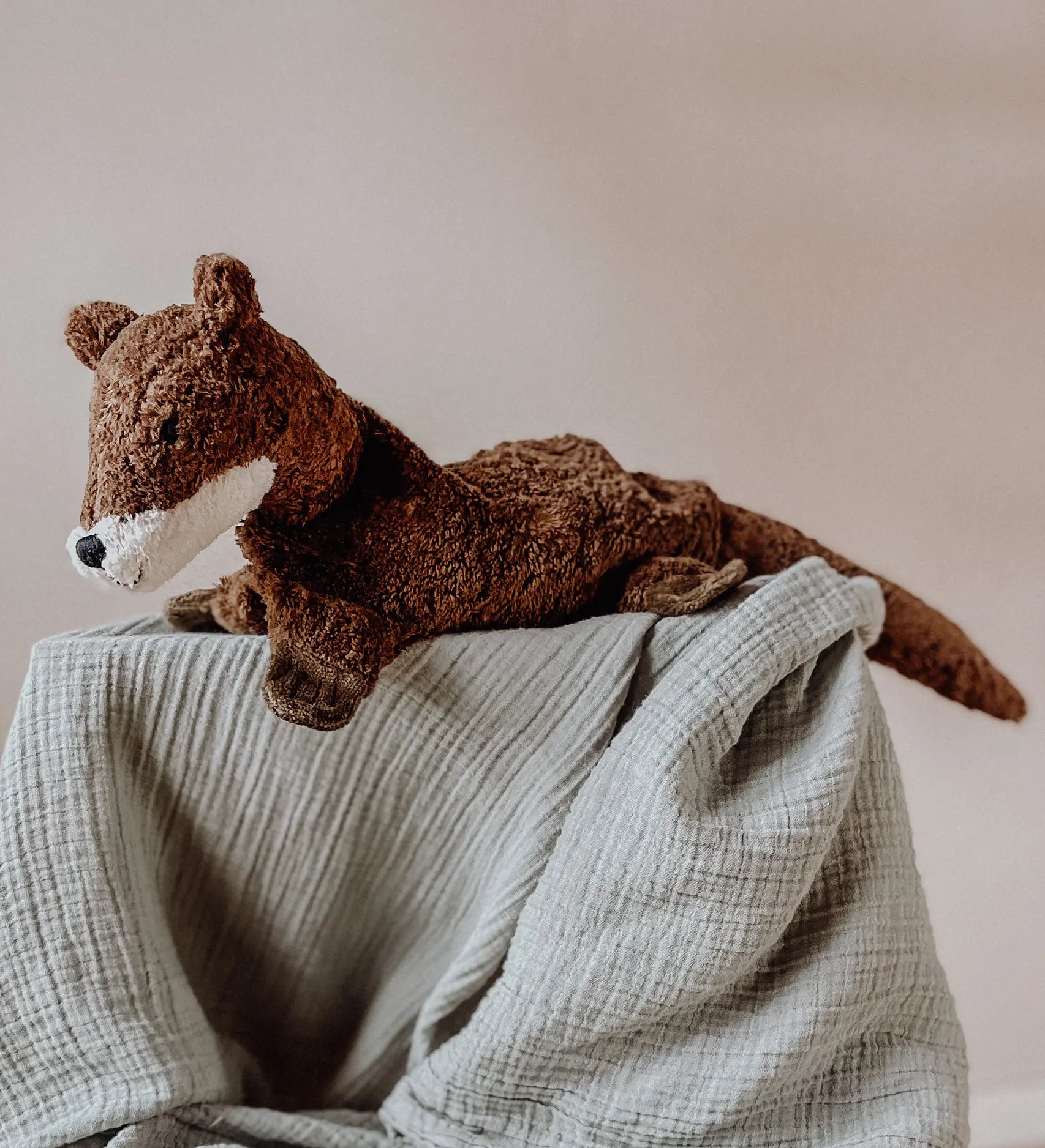 Senger Naturwelt seal, a small brown cuddly soft toy made from natural materials, on a grey muslin blanket.