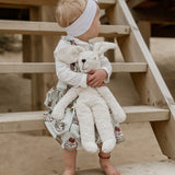 Senger Naturwelt Floppy White Rabbit Size Large, made from organic materials, held by child on a beach.
