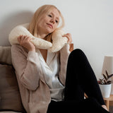 A woman holding the Senger nursing and neck soft warm cushion around the neck. Cushion available at Babipur. 