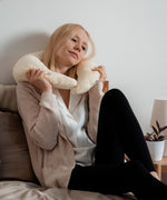 A woman holding the Senger nursing and neck soft warm cushion around the neck. Cushion available at Babipur. 