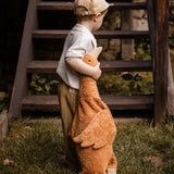 A child holding a Senger Large Cuddly Goose organic soft toy in a dark orange Rust colour. These soft toys are created from the highest quality, sustainable and traceable natural materials. Senger cuddly animal toys and soft dolls are handmade in Germany with love and attention to detail and we are proud Senger stockists here at Babipur. 