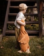 A child holding a Senger Large Cuddly Goose organic soft toy in a dark orange Rust colour. These soft toys are created from the highest quality, sustainable and traceable natural materials. Senger cuddly animal toys and soft dolls are handmade in Germany with love and attention to detail and we are proud Senger stockists here at Babipur. 