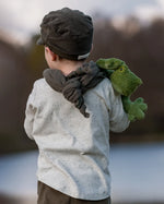 Senger Naturwelt Cuddly Green Small Frog soft toy, made from organic cotton, over child's shoulder.