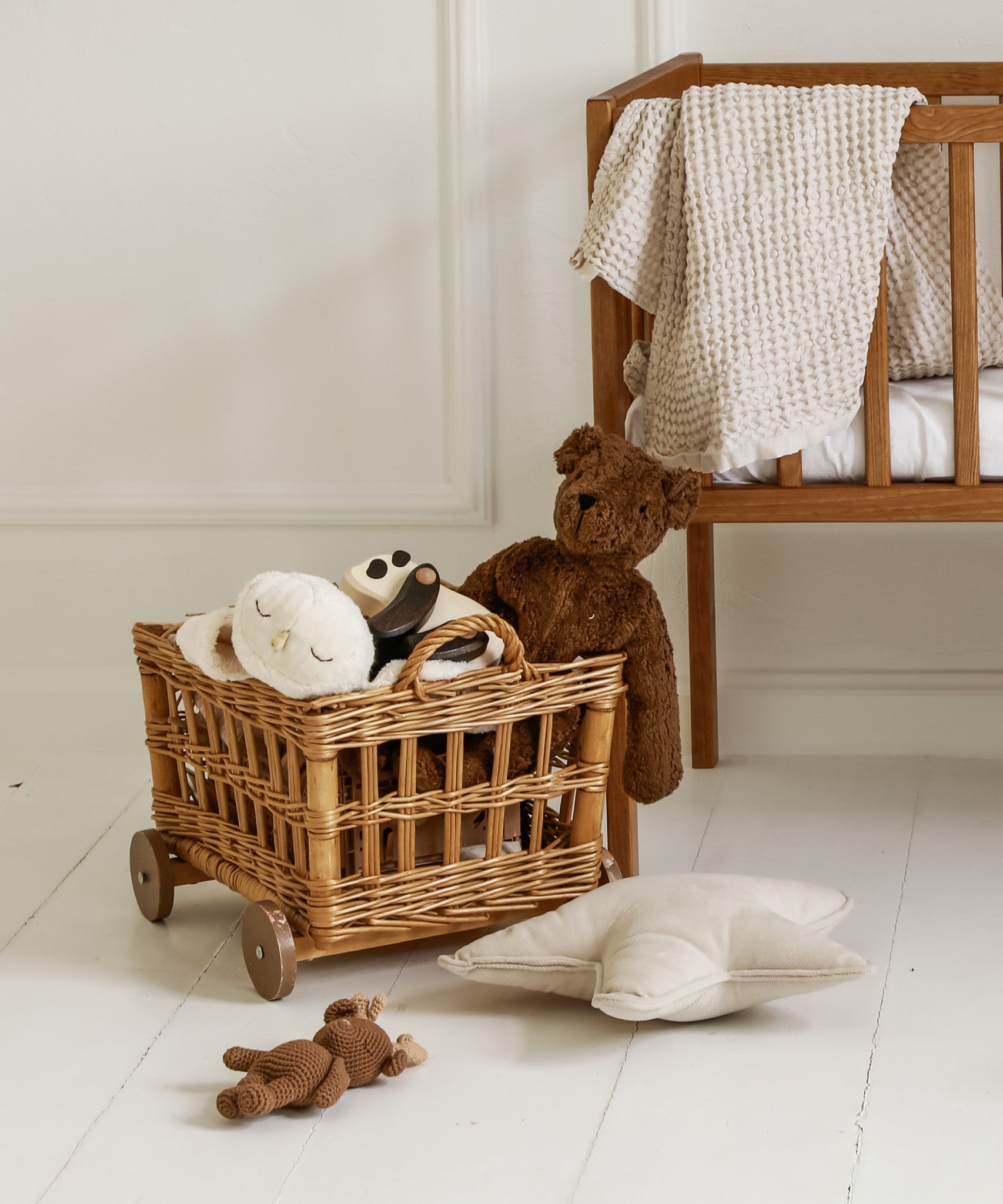 A GOTS organic cotton snowy owl soft toy by Senger available at Babipur sitting in a play basket next to a Senger brown cuddly bear 