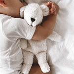A sleeping baby cuddled up to the Senger Small Cuddly Polarbear